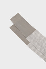 Close-up of the Prince of Wales jacquard pattern and cuff on Bresciani Silvio socks, in pearl and white.