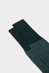 Close-up of the herringbone pattern and the high cuff on Bresciani Giulio socks, in a dark green color.
